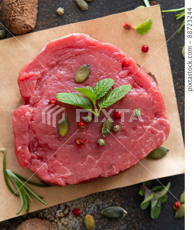 Raw beef fillet steak with herbs and spices on dark table top view Raw beef fillet steak with herbs and spices on dark table top view 88723244