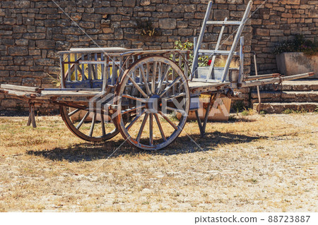 Medieval wooden vehicle with metal tire on wheel rim ready to move, engineering ideas Medieval wooden vehicle with metal tire on wheel rim ready to move, engineering ideas 88723887