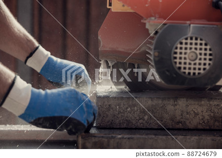 Retro image of workman using an angle grinder or circular saw to cut a concrete block Retro image of workman using an angle grinder or circular saw to cut a concrete block 88724679