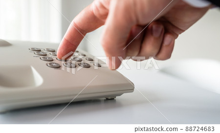 Low angle closeup view of male hand dialing a phone number 88724683