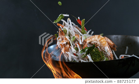 Freeze Motion of Wok Pan and Flying Ingredients in the Air. 88725177