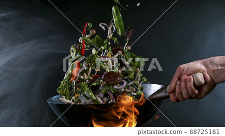 Freeze Motion of Wok Pan and Flying Ingredients in the Air. 88725181