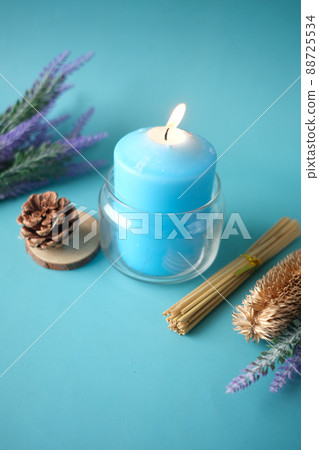 Natural candle in a glass jar and dried flowers on blue Natural candle in a glass jar and dried flowers on blue 88725534