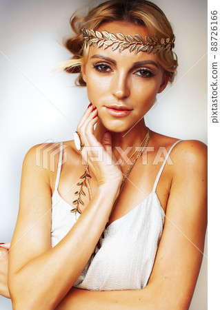 young blond woman dressed like ancient greek godess, gold jewelry closeup isolated, beautiful girl hands manicured red nails young blond woman dressed like ancient greek godess, gold jewelry closeup isolated, beautiful girl hands manicured red nails 88726166