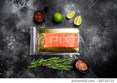 Vacuum packed salmon portion fillet, with herbs, on black dark stone table background, top view flat lay, with copy space for text Vacuum packed salmon portion fillet, with herbs, on black dark stone table background, top view flat lay, with copy space for text 88726718
