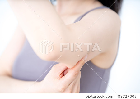 A woman checking the slack in her upper arm [Parts cut] 88727005