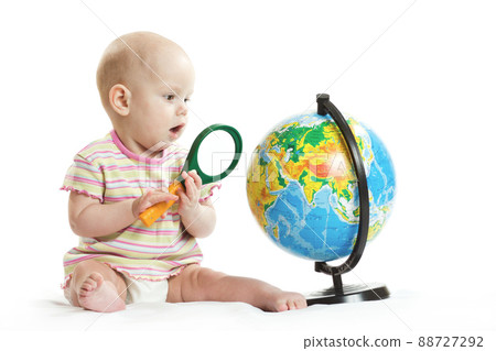 girl on a white background at the table with a globe and notebooks girl on a white background at the table with a globe and notebooks 88727292