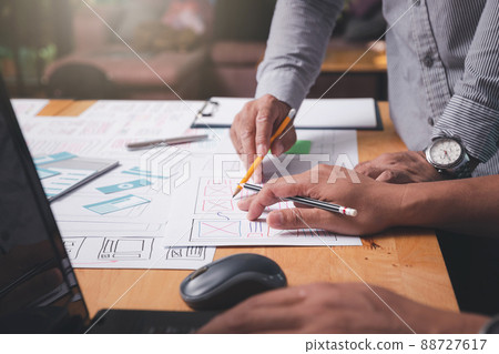 UX or UI designers designing on their smartphone application layout prototype project. 88727617