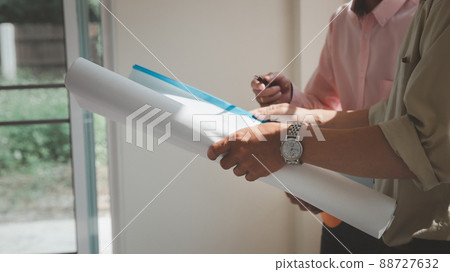 Confident team of architect working together in a office.Then discussing about new startup project on desk. Architect discuss with engineer about project in office, architectural concept. 88727632