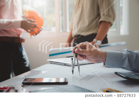 Confident team of architect working together in a office.Then discussing about new startup project on desk. Architect discuss with engineer about project in office, architectural concept. 88727633