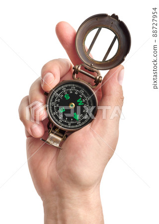 Hand holding traditional magnetic compass 88727954