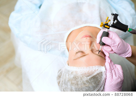 Image of a young beautiful woman dressed as a patient, lying on a couch in a cosmetology clinic. 88728068