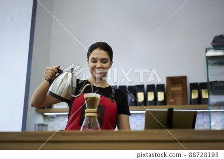 Skilled female employee using filter making hot aroma coffee enjoying work Skilled female employee using filter making hot aroma coffee enjoying work 88728193
