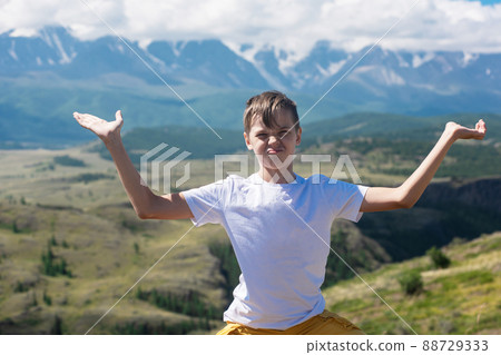 A child funny boy on the Altai mountain background. A child funny boy on the Altai mountain background. 88729333