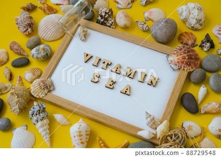Composition sheet white paper text VITAMIN SEA, seashells, pebbles, mockup on yellow background. Blank, top view, still life, flat lay. sea vacation travel concept tourism and resorts. 88729548