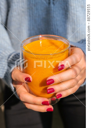 Unrecognizable woman holding Pumpkin smoothie spiced latte. Autumn coffee with spicy pumpkin flavor seasonal hot drink. Fall Drinks for Halloween and Thanksgiving Unrecognizable woman holding Pumpkin smoothie spiced latte. Autumn coffee with spicy pumpkin flavor seasonal hot drink. Fall Drinks for Halloween and Thanksgiving 88729555
