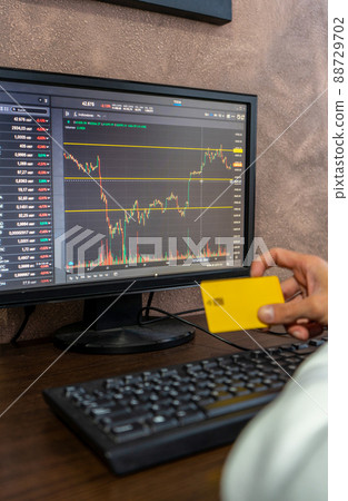 Digital graph rising and falling, device display and hand with credit card. Business corporate communication, stock market changes on foreground. Concept of online paying 88729702