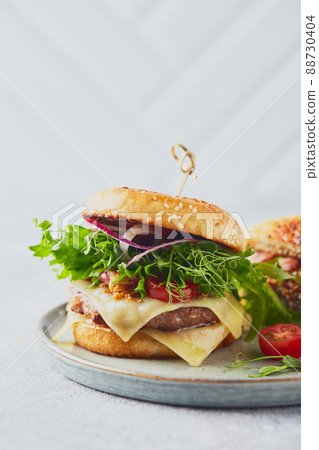 Two burgers with veal cutlet and herbs on wooden cutting board 88730404