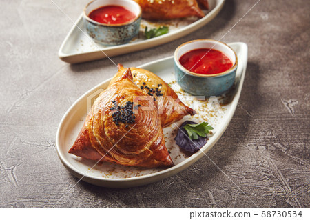 Samosa, samsa meat stuffed pies. Uzbek national dish samosa. Concept of Central Asian, South and East Asian cuisine Samosa, samsa meat stuffed pies. Uzbek national dish samosa. Concept of Central Asian, South and East Asian cuisine 88730534