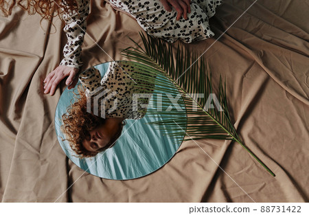 Young red haired woman looking at her reflection in mirror and enjoying her natural beauty Young red haired woman looking at her reflection in mirror and enjoying her natural beauty 88731422