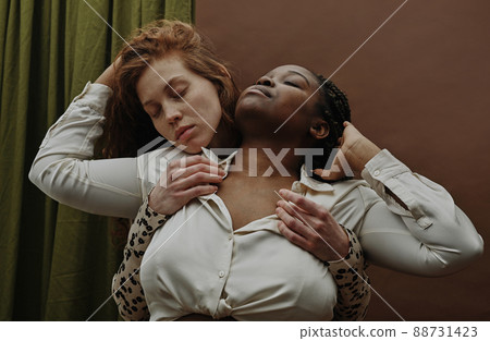 Portrait of young sensual white woman standing behind her girlfriend and embracing 88731423