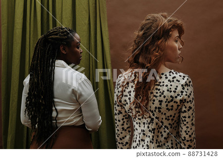 Rear view of two young diverse women standing and looking in the same direction, they are in solidarity with each other Rear view of two young diverse women standing and looking in the same direction, they are in solidarity with each other 88731428