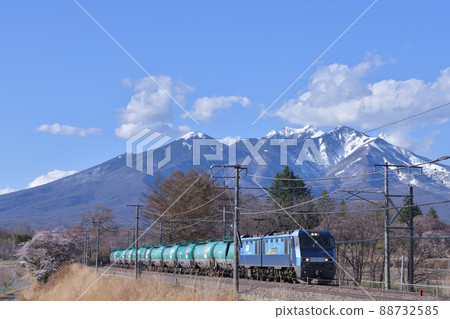 EH200 series freight train that goes to the Chuo Main Line in spring with Yatsugatake in the snow covered in Nagasaka Town, Hokuto City 88732585