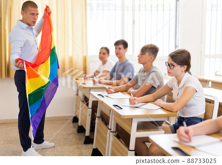 Teenage schoolgirl listening to teacher talking about LGBT at lesson 88733025