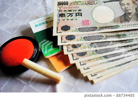 Seals and passbooks placed against a white background, 10,000 yen bills lined up 88734485