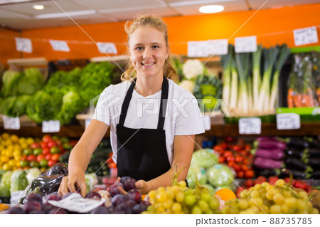 Teenage girl at her first job in vegetable store 88735785