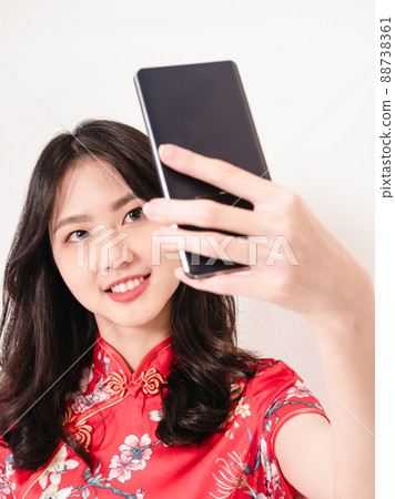 Smiling young asian woman in traditional cheongsam Smiling young asian woman in traditional cheongsam 88738361
