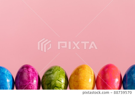 Easter eggs arranged in a single row on a solid pink background. Easter. Easter eggs arranged in a single row on a solid pink background. Easter. 88739570
