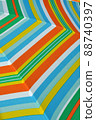 Closeup of green, orange, blue and white striped summer parasol 88740397