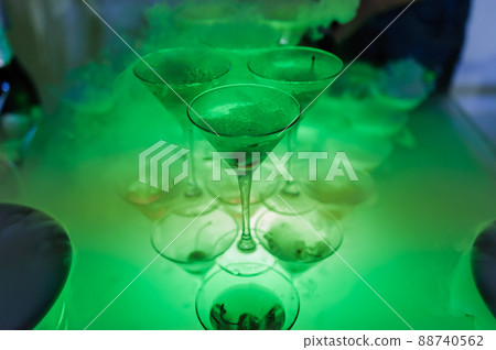 Glasses of champagne with dry ice. Champagne slide. Pyramid or fountain made of champagne glasses Glasses of champagne with dry ice. Champagne slide. Pyramid or fountain made of champagne glasses 88740562