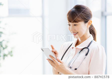一名女醫務人員在設施中操作智能手機 88741578