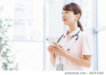 一名女醫務人員在設施中操作智能手機 88741580