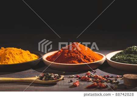 Various colorful herbs and spices on wooden table.  Dark background with copy space. Cooking ingredients and condiments concept. 88742028