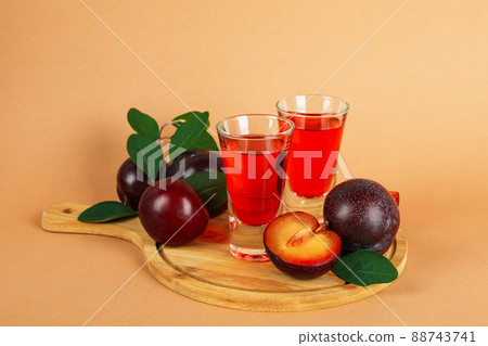 Plum brandy shots and ingredients on beige background 88743741