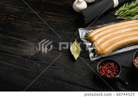 Raw chicken sausages in vacuum package, on black wooden table background, with copy space for text Raw chicken sausages in vacuum package, on black wooden table background, with copy space for text 88744525