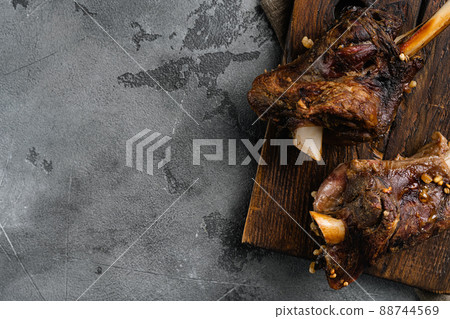Braised Lamb Shanks with Sauce and Herbs, on gray stone table background, top view flat lay, with copy space for text Braised Lamb Shanks with Sauce and Herbs, on gray stone table background, top view flat lay, with copy space for text 88744569
