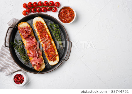 Toasted bread slice with fresh tomatoes and cured ham, on white stone table background, top view flat lay, with copy space for text Toasted bread slice with fresh tomatoes and cured ham, on white stone table background, top view flat lay, with copy space for text 88744761