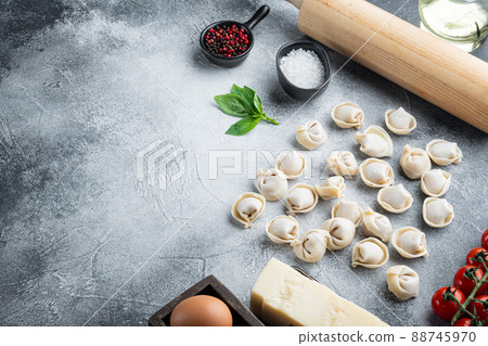 Italian tortellini with fresh ricotta leaves and tomatoes, on gray background , with copyspace and space for text 88745970