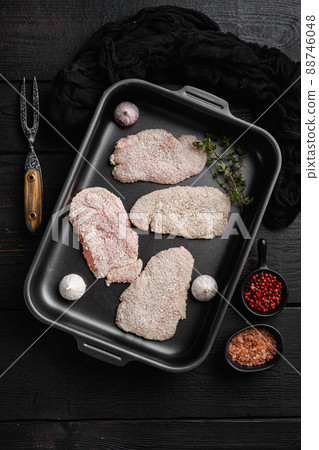 Raw schnitzel chicken meat set, on black wooden table background, top view flat lay Raw schnitzel chicken meat set, on black wooden table background, top view flat lay 88746048