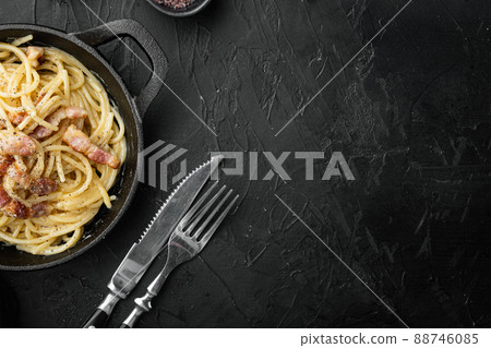 Pasta with egg sauce and ham, in cast iron frying pan, on black stone background, top view flat lay, with copy space for text Pasta with egg sauce and ham, in cast iron frying pan, on black stone background, top view flat lay, with copy space for text 88746085
