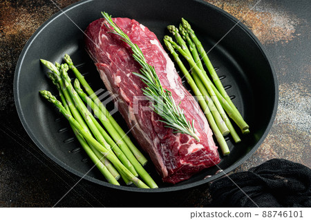Beef fillet mignon cut raw, on frying cast iron pan, on old dark rustic background 88746101
