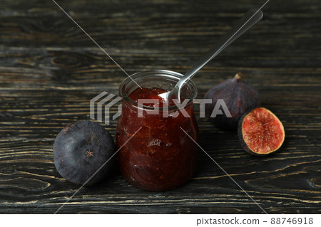 Jar with fig jam and spoon, and ingredients on wooden background 88746918