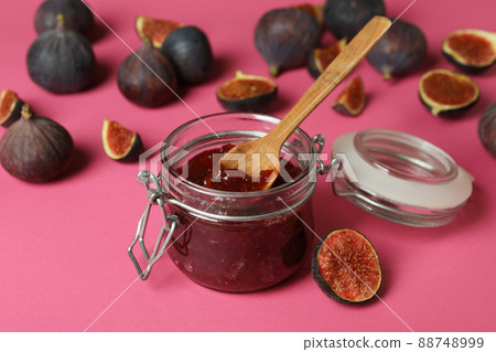 Jar with fig jam and spoon, and ingredients on pink background Jar with fig jam and spoon, and ingredients on pink background 88748999