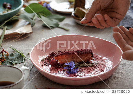 Process of decorating rustic style table with craft plates, linen tableclothe and napkins , gluten free pastry and wild berries 88750030