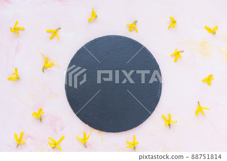 Black round slate plate board on pink background with spring yellow flowers, product or menu mockup Black round slate plate board on pink background with spring yellow flowers, product or menu mockup 88751814