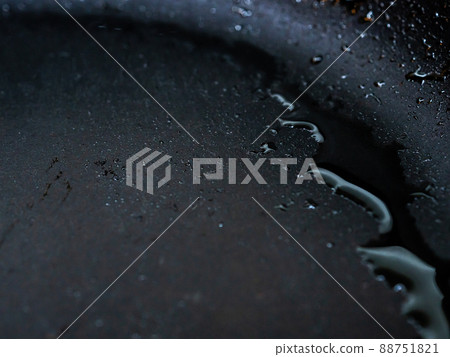 Selective focus on drops of hot oil on the surface of the pan. Abstract food background 88751821